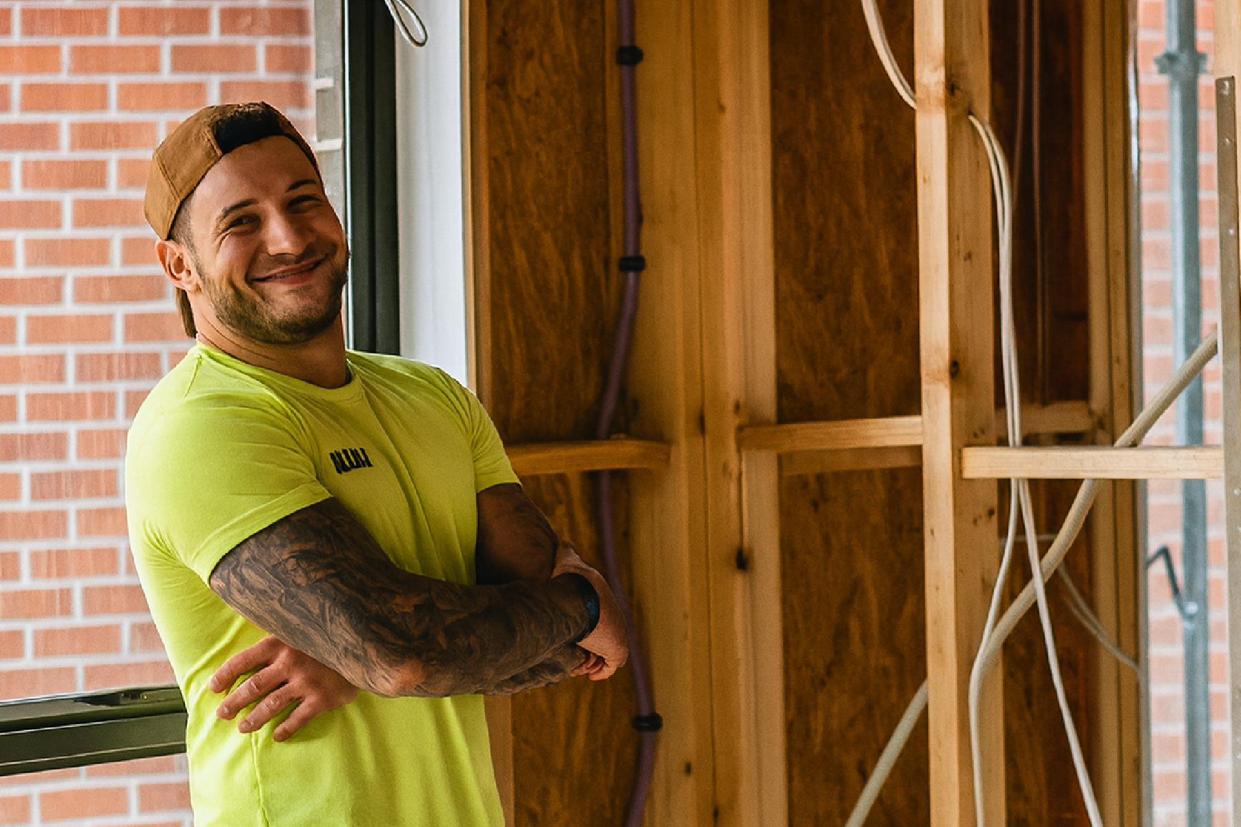 Builder standing inside a partially framed room on a renovation site.