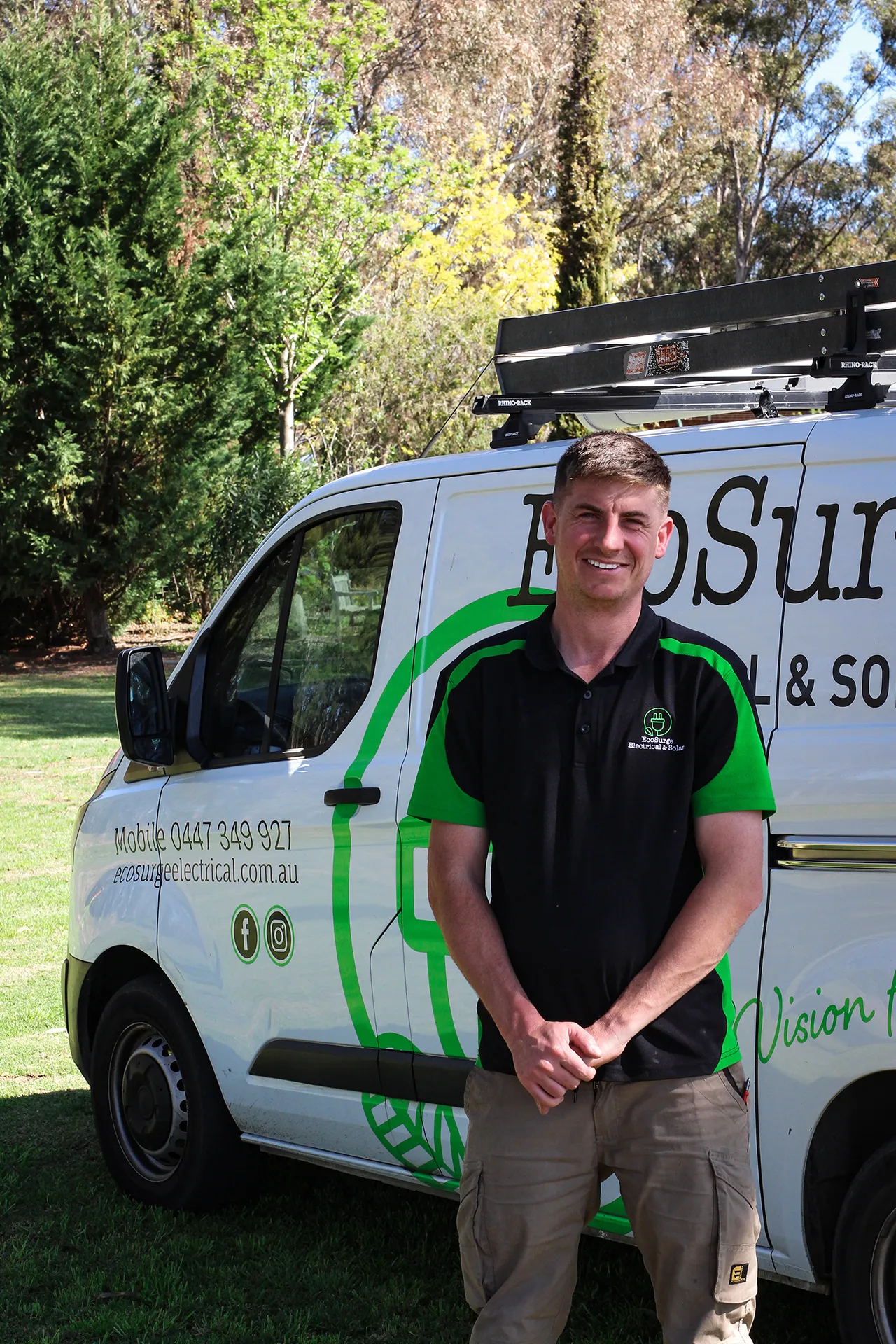 Electrician Matt Dyson standing in front of a branded service van with EcoSurge Electrical logo and contact details. Tradie website in Adelaide.